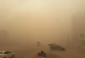 Dust storm engulfing a city street with decreased visibility