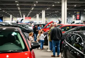Crowd enjoying the Arizona International Auto Show with new vehicles on display.