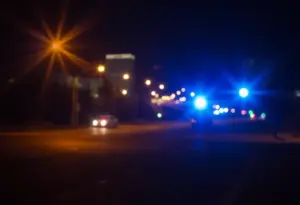 Police lights illuminating a quiet Phoenix street at night.