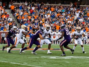 Dynamic college football game atmosphere with athletes in action.