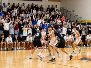 High school basketball game with energetic players and cheering fans.