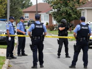 Police officers investigating a crime scene after a shooting and armed confrontation.