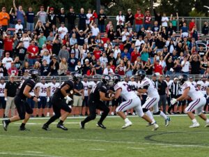 Millennium High School football players competing on the field