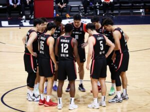 Arizona Wildcats basketball team in a huddle during a game.