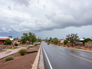 Wet roads in Phoenix after a rainfall, with cloudy skies above.