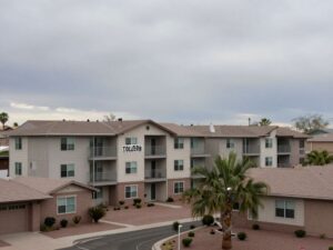 Exterior view of a typical apartment building in Tolleson, Arizona, in a news photography style.